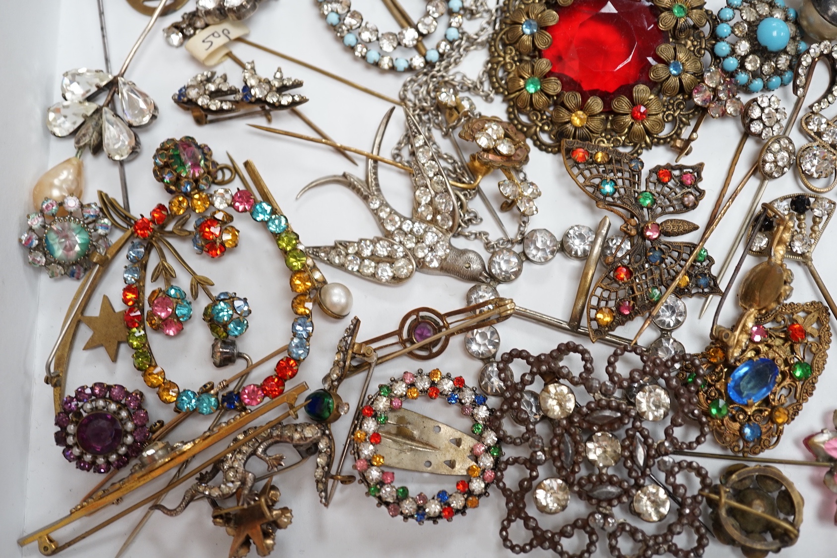 A quantity of assorted coloured and white paste jewellery, including brooches and buckles.